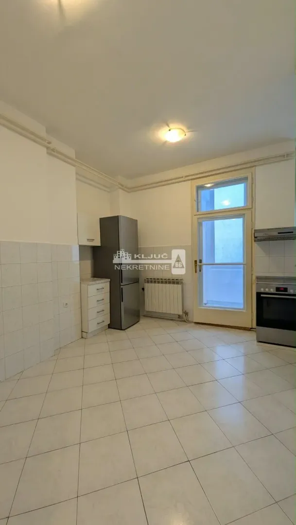 Small kitchen with a refrigerator, stove, and access to the terrace.