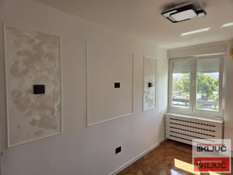 Prazna prostorija sa dekorativnim zidnim lajsnama i parketom. - image 6