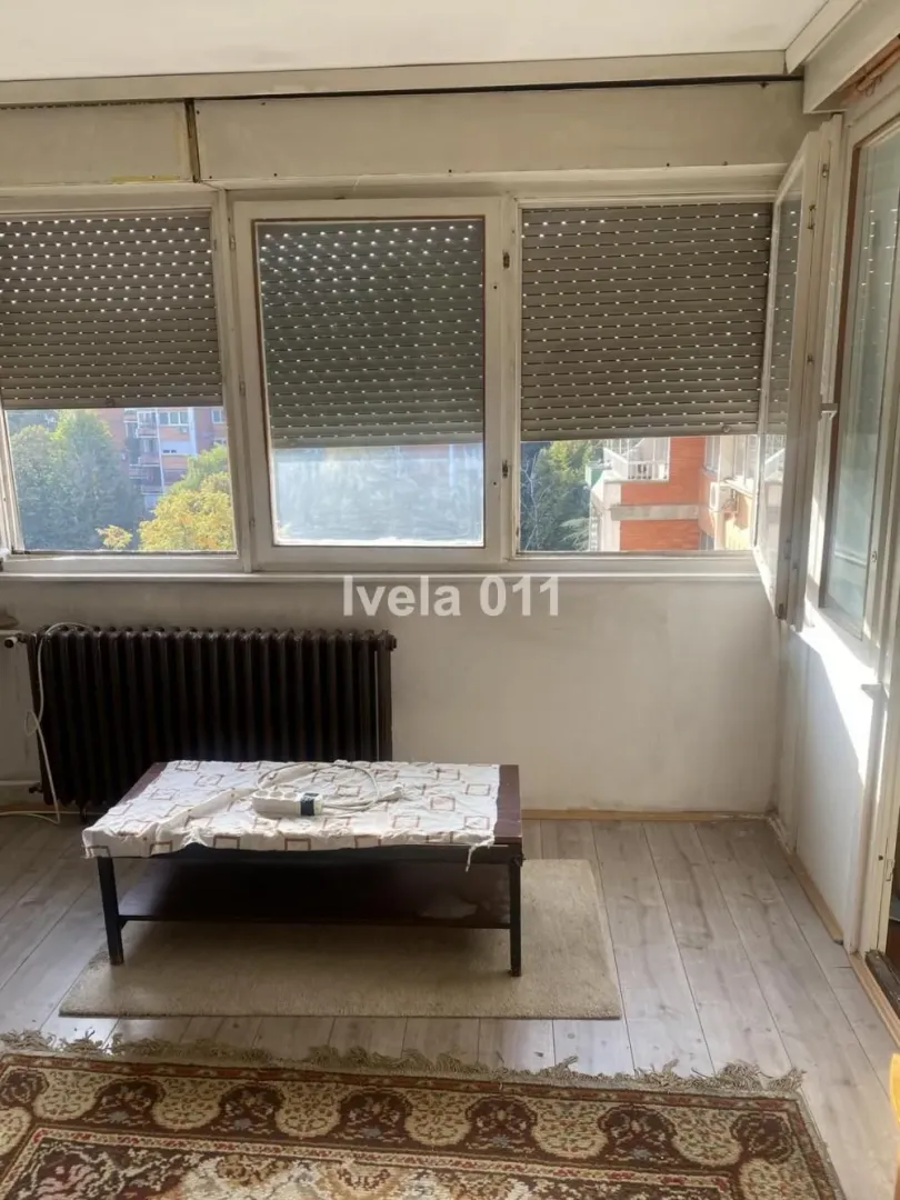Enclosed terrace with large windows and a radiator.