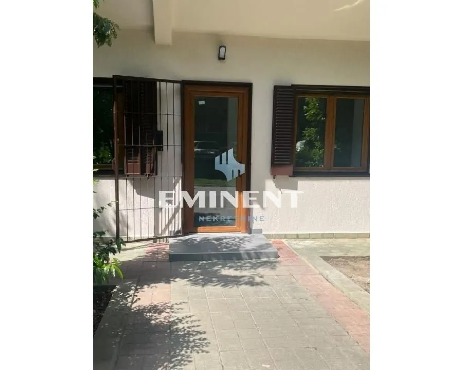 Entrance to the house with a paved yard and windows.