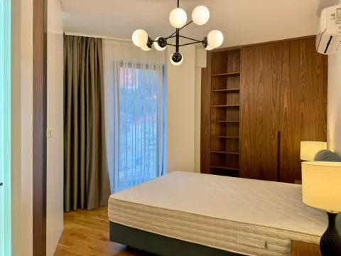 Bedroom with a double bed, wooden wardrobe, and modern chandelier. - image 3