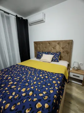 Spavaća soba sa bračnim krevetom, noćnim stočićem i klima uređajem. - image 9