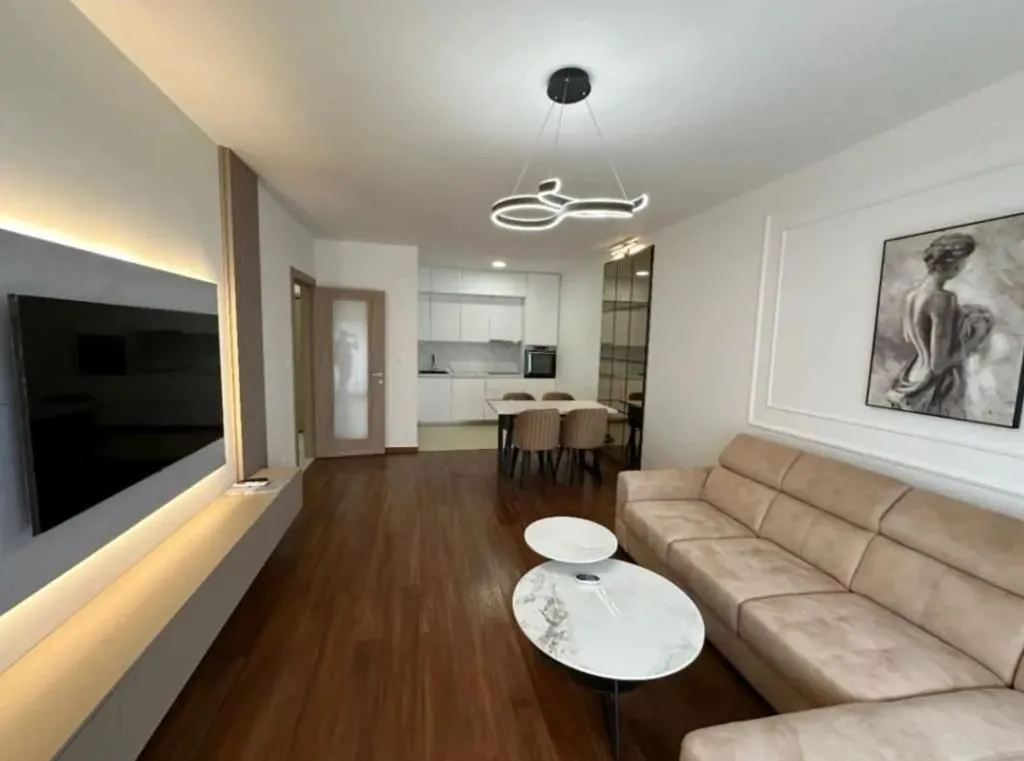 Living room with a sofa, TV, and an adjoining dining area.
