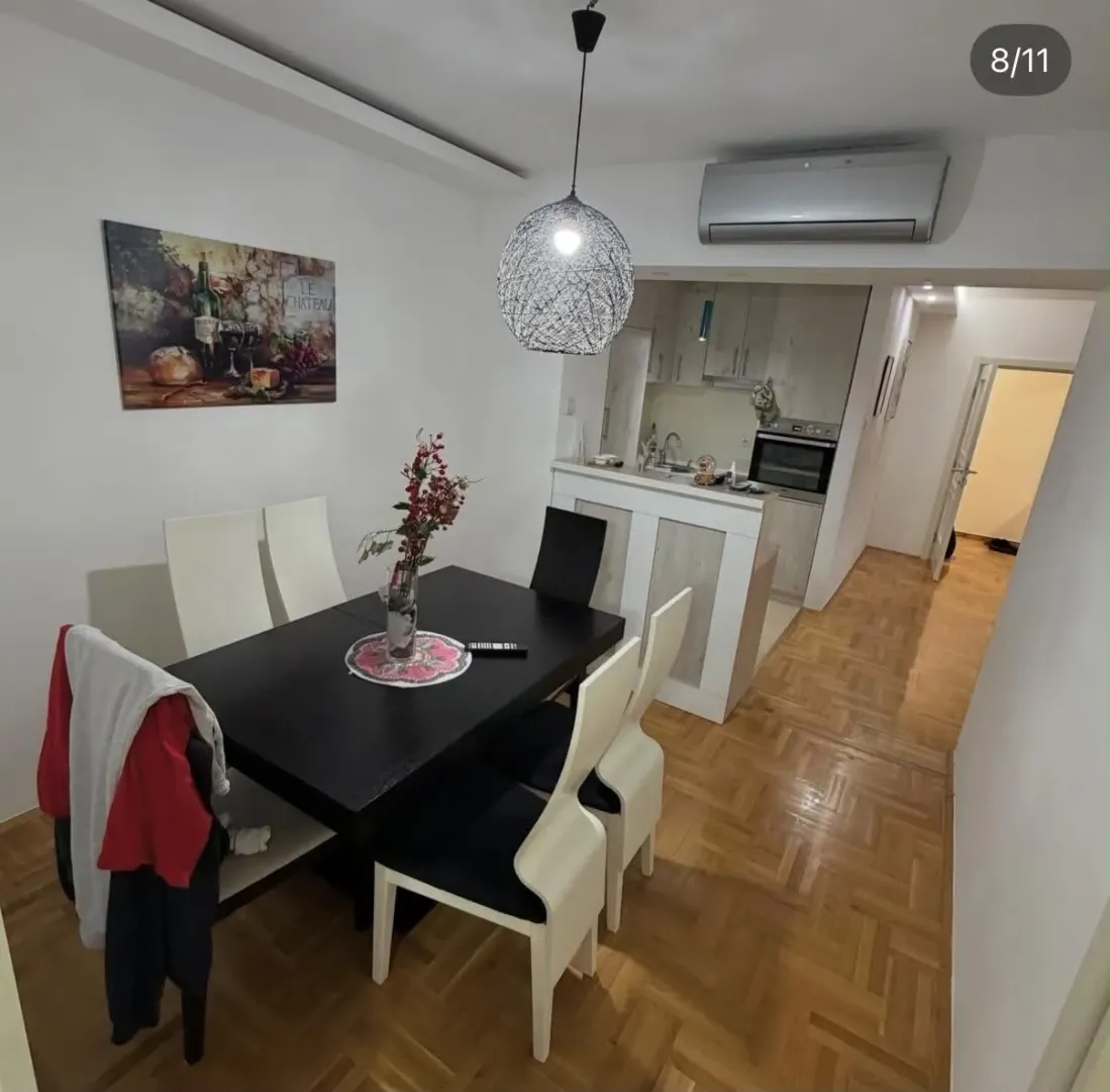 Dining area with a black table and chairs, connected to the kitchen.