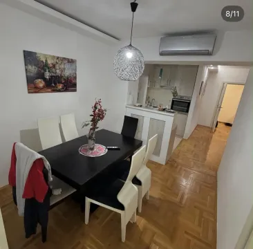 Dining area with a black table and chairs, connected to the kitchen. - image 8