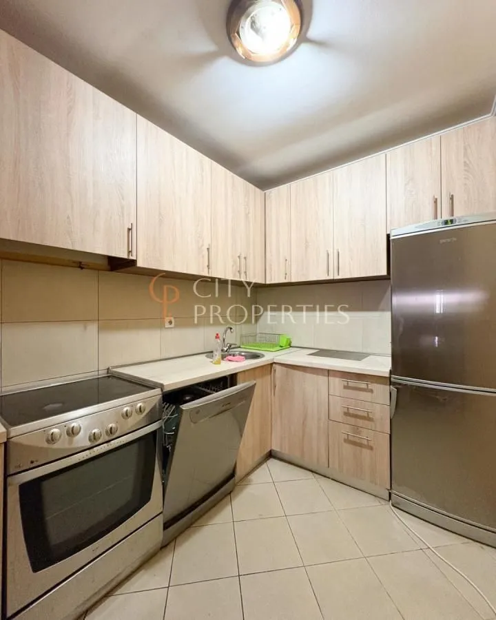 Smaller kitchen with wooden cabinets, stove, dishwasher, and refrigerator.