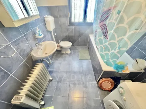 Tiled bathroom featuring a bathtub, washbasin, and toilet. - image 4