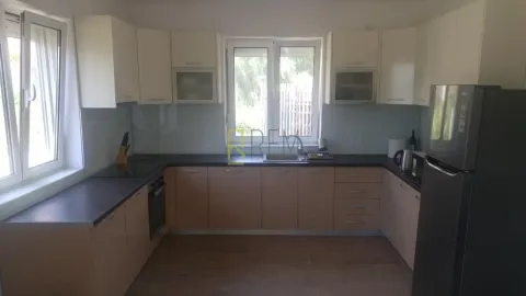 U-oblik kuhinja sa bež elementima i tamnom radnom površinom. - image 2