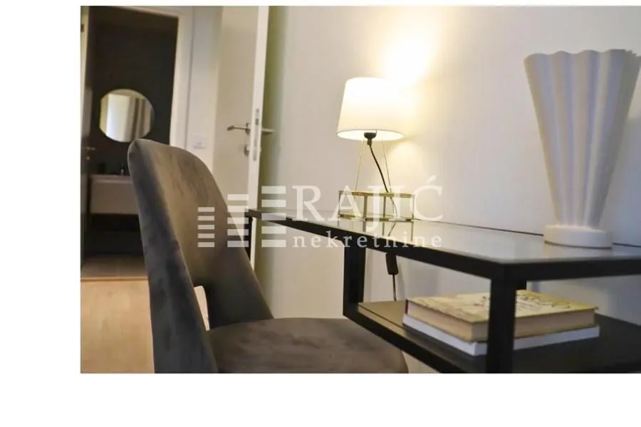 A desk with a chair and a lamp in the bedroom.