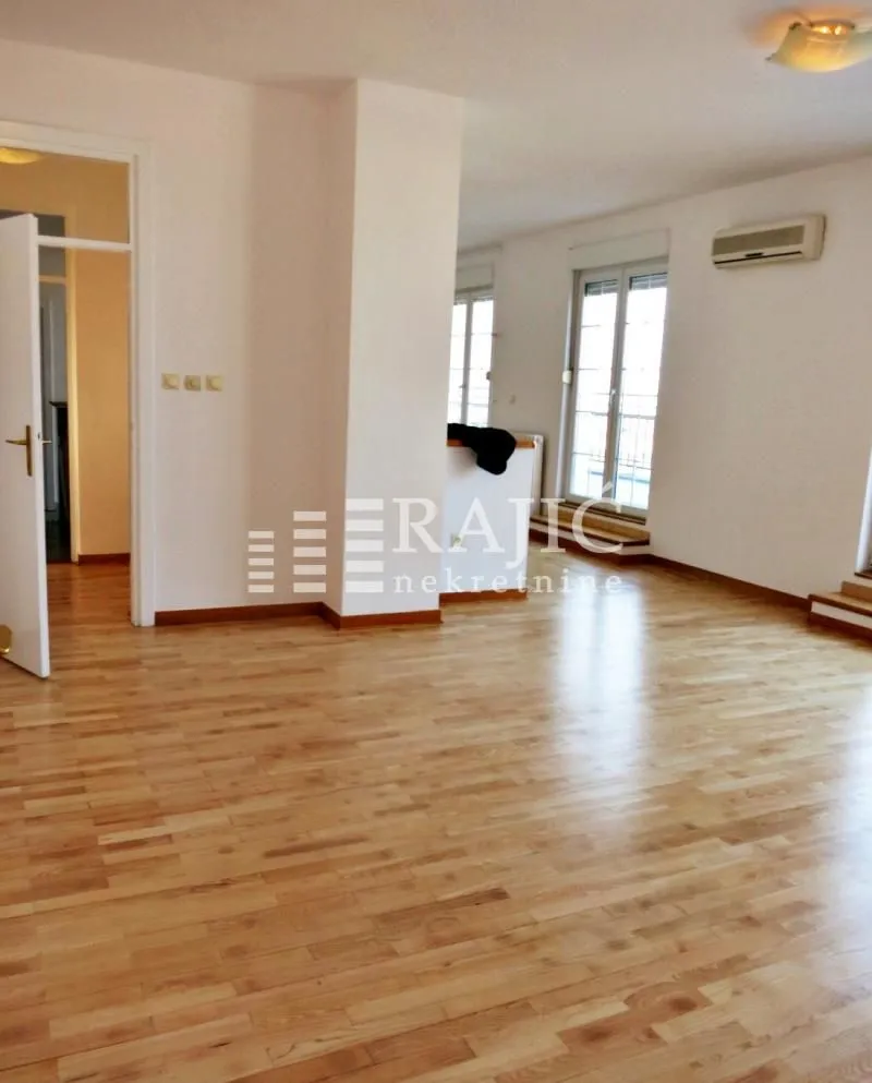 Spacious living room with parquet flooring and access to the terrace.