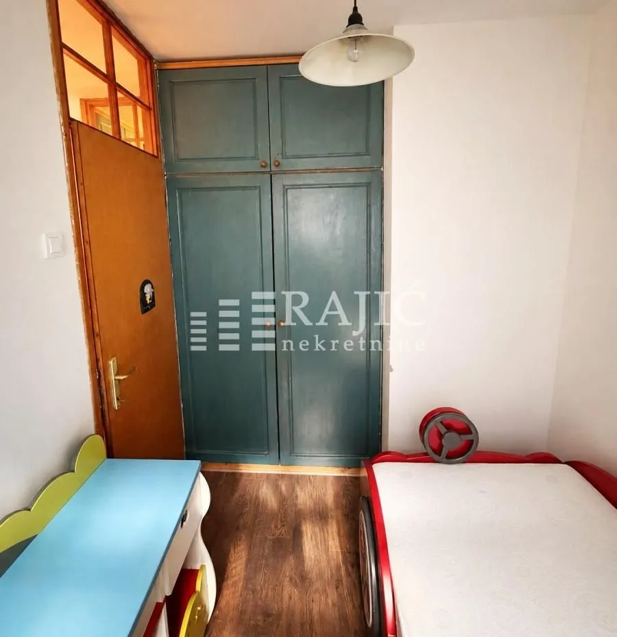 Children's bedroom with a bed and built-in wardrobe.