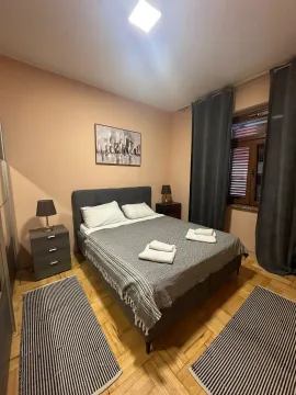 Uređena spavaća soba sa bračnim krevetom, noćnim stočićima i prozorom. - image 18