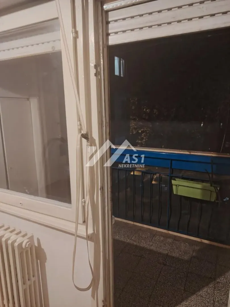 Pogled kroz prozor i vrata na terasu noću.