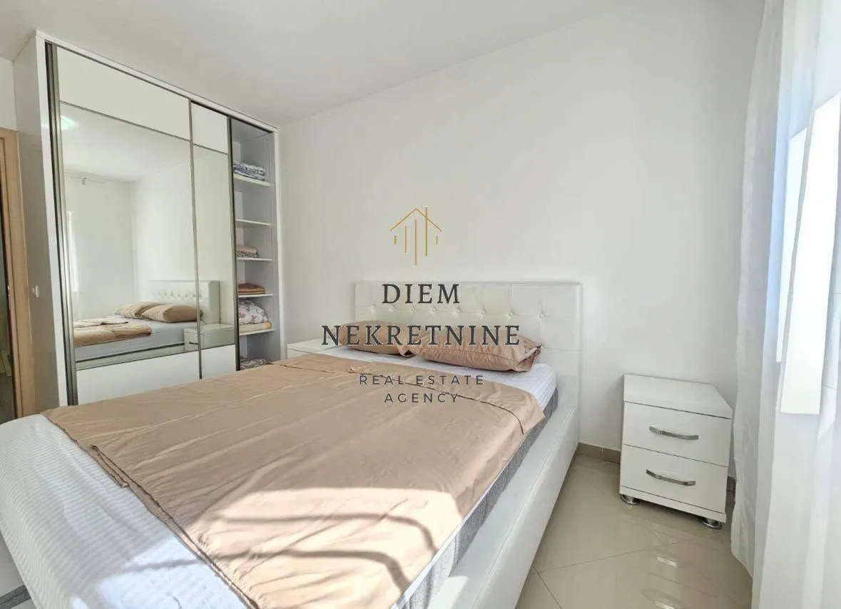 Furnished bedroom with a double bed and a mirrored built-in wardrobe.