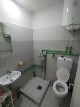 Smaller bathroom with a walk-in shower area, sink, and toilet. - image 4