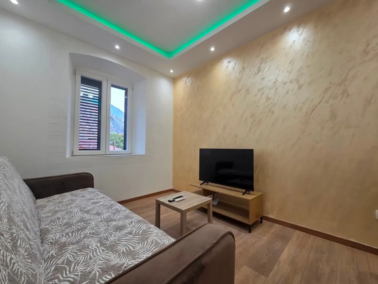 Living room with a sofa, television, and decorative lighting.