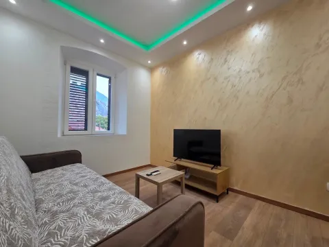Living room with a sofa, television, and decorative lighting. - image 3