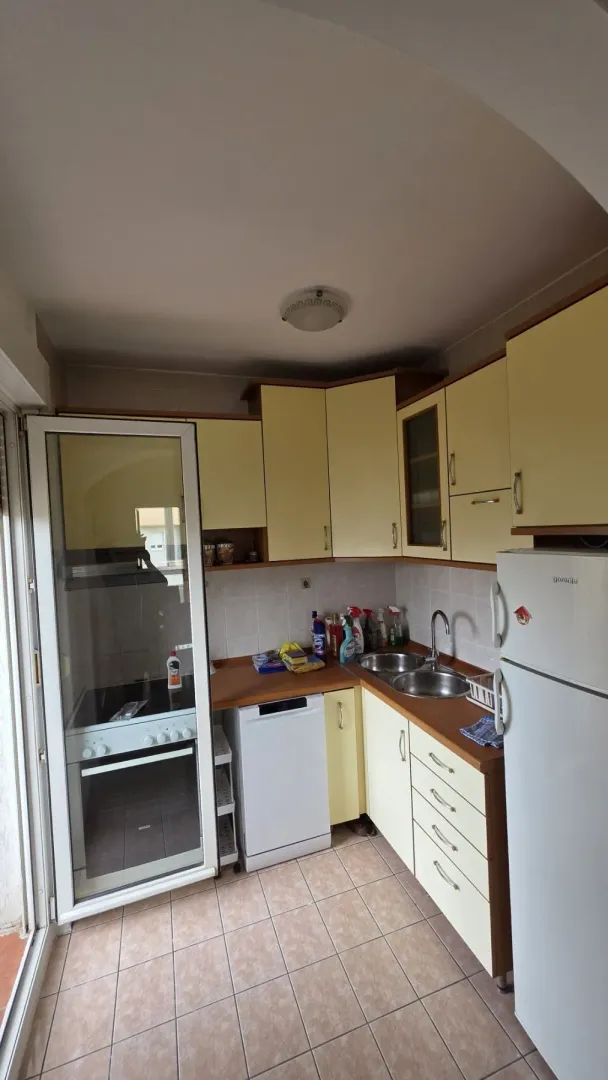 A simple kitchen with light cabinets and built-in appliances.