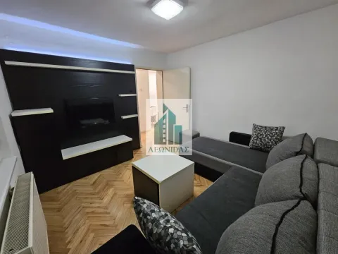 Living room with a sofa set, TV unit, and parquet flooring. - image 2