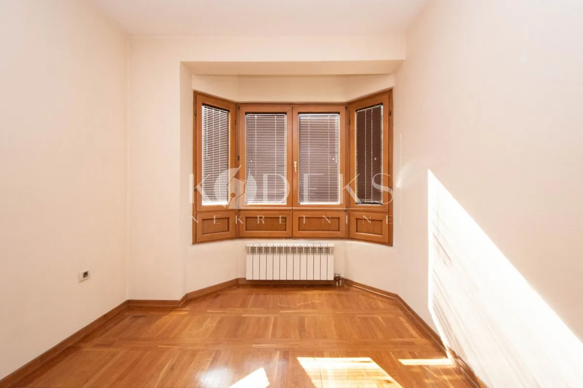 Empty room with wooden windows and parquet flooring.