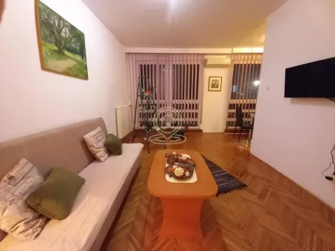 Living room with a sofa, coffee table, and a wall-mounted TV. - image 5
