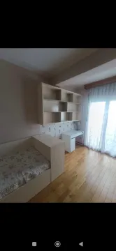 Children's bedroom with a bed, desk, and shelving unit. - image 14