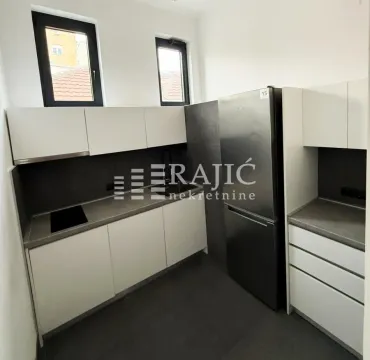 Modern white kitchen with grey countertops and a refrigerator. - image 3