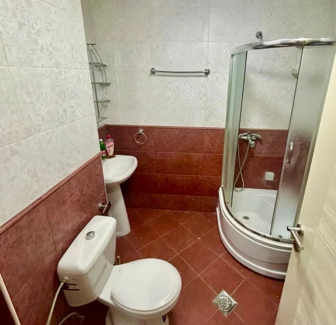 Manje kupatilo sa tuš kabinom, umivaonikom i toaletom.