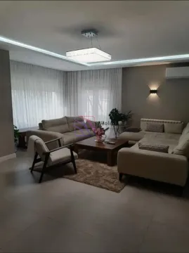 Spacious living room with seating furniture, coffee table, and modern lighting. - image 5
