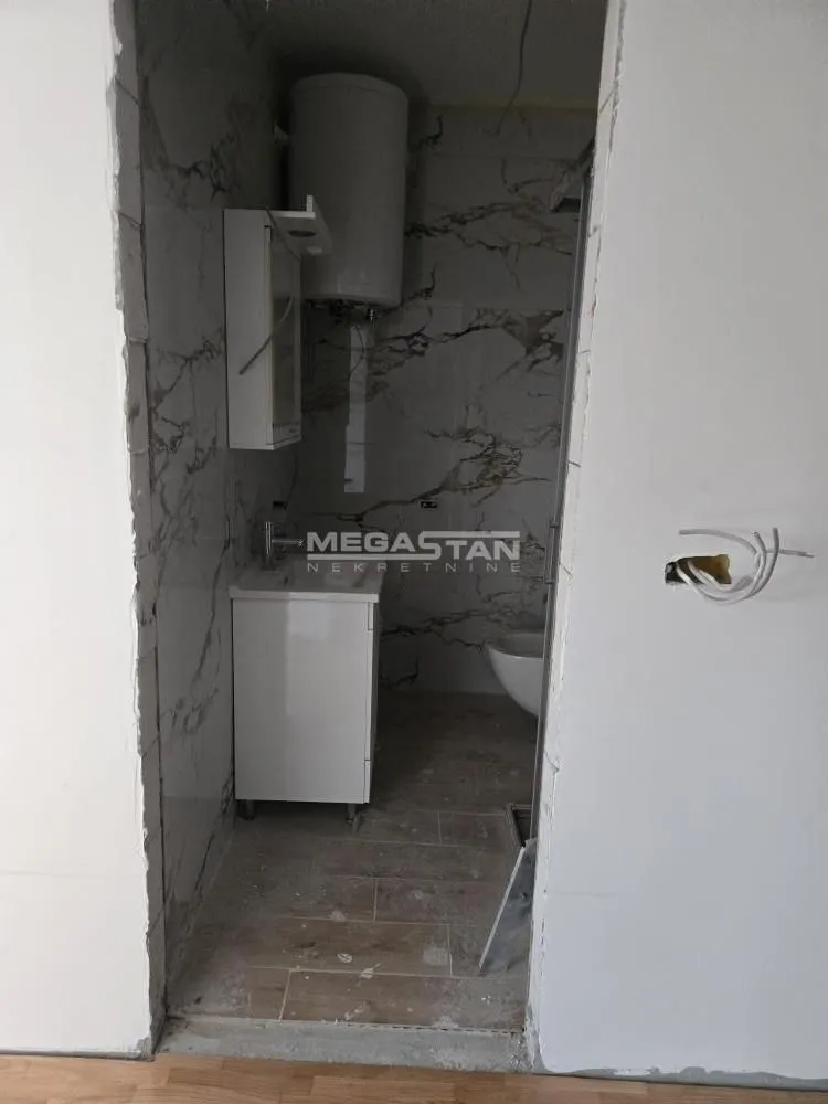 Pogled na kupatilo u toku renoviranja sa postavljenim pločicama i sanitarijama.