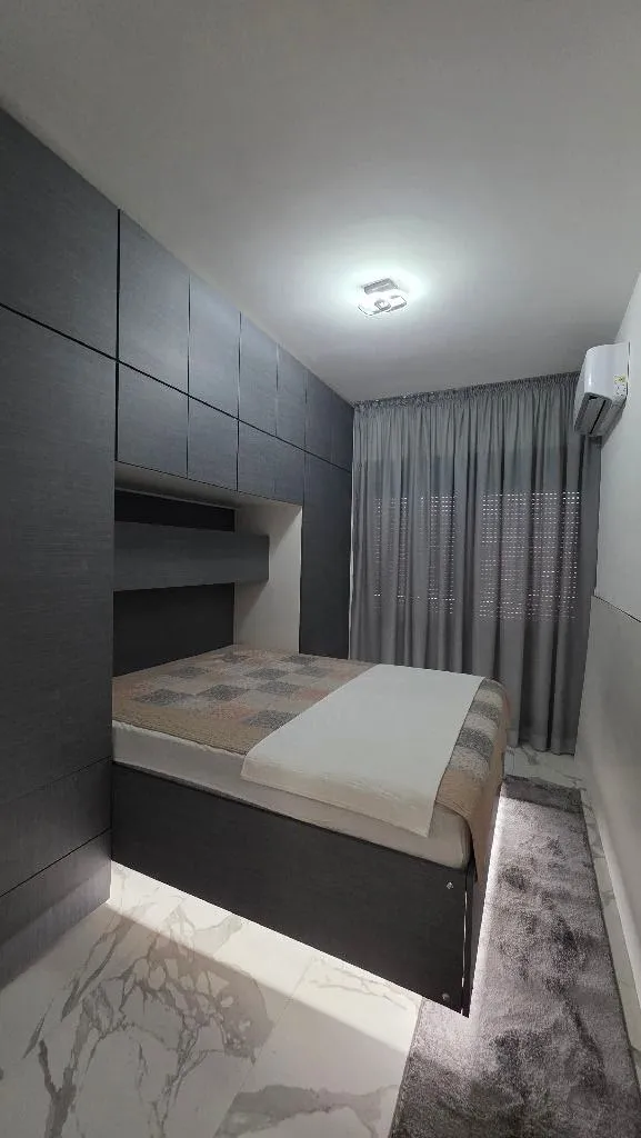 Modern bedroom with built-in wardrobes and a bed.