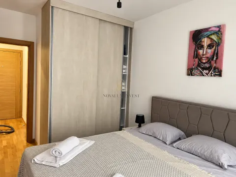 Namještena spavaća soba sa bračnim krevetom, velikim garderoberom i umjetničkom slikom na zidu. - image 10