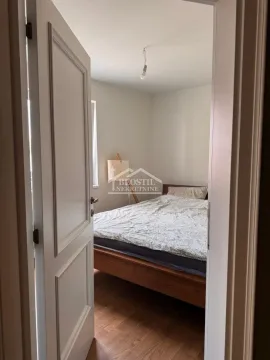 Pogled kroz otvorena vrata na opremljenu spavaću sobu sa drvenim krevetom. - image 5