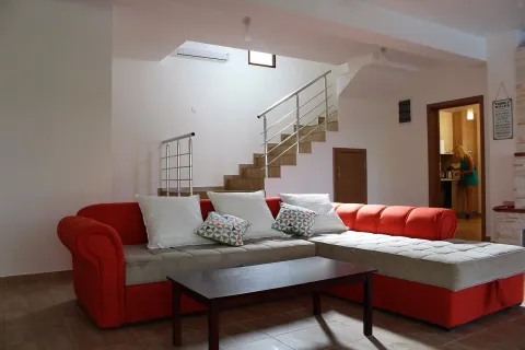 Living room with a red sectional sofa and stairs in the background. - image 13