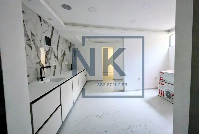Modern kitchen with white cabinetry and a marble-patterned backsplash.
