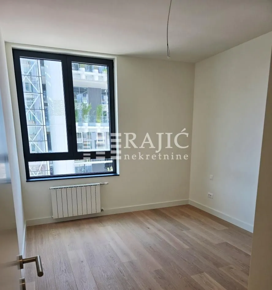 Empty room with parquet flooring and a window.