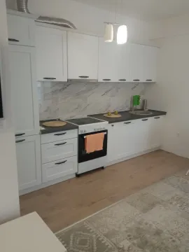 Svijetla kuhinja sa bijelim elementima i podom od laminata. - image 3