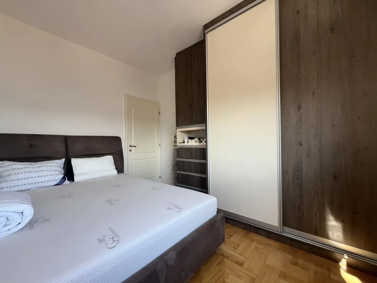 Furnished bedroom with a double bed and a large built-in wardrobe.