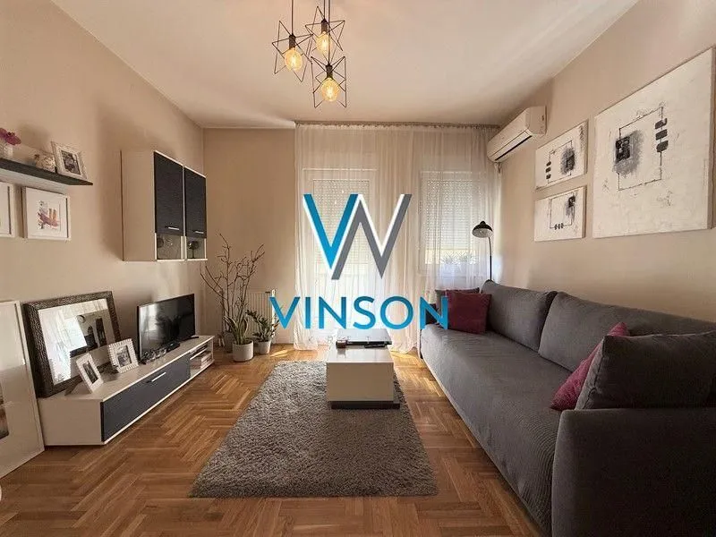 Nameštena dnevna soba sa garniturom i TV komodom.
