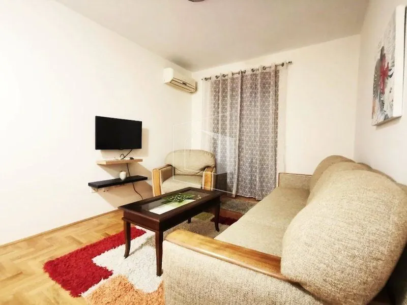 Living room with a sofa set, coffee table, and wall-mounted TV.