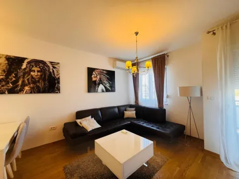 Dnevna soba sa ugaonom garniturom, stočićem i umjetničkim slikama na zidu. - image 14