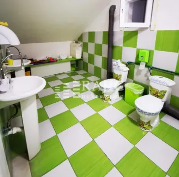 View of a bathroom with green and white tiles. - image 9