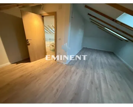 Empty attic room with wooden ceiling beams and laminate flooring. - image 5
