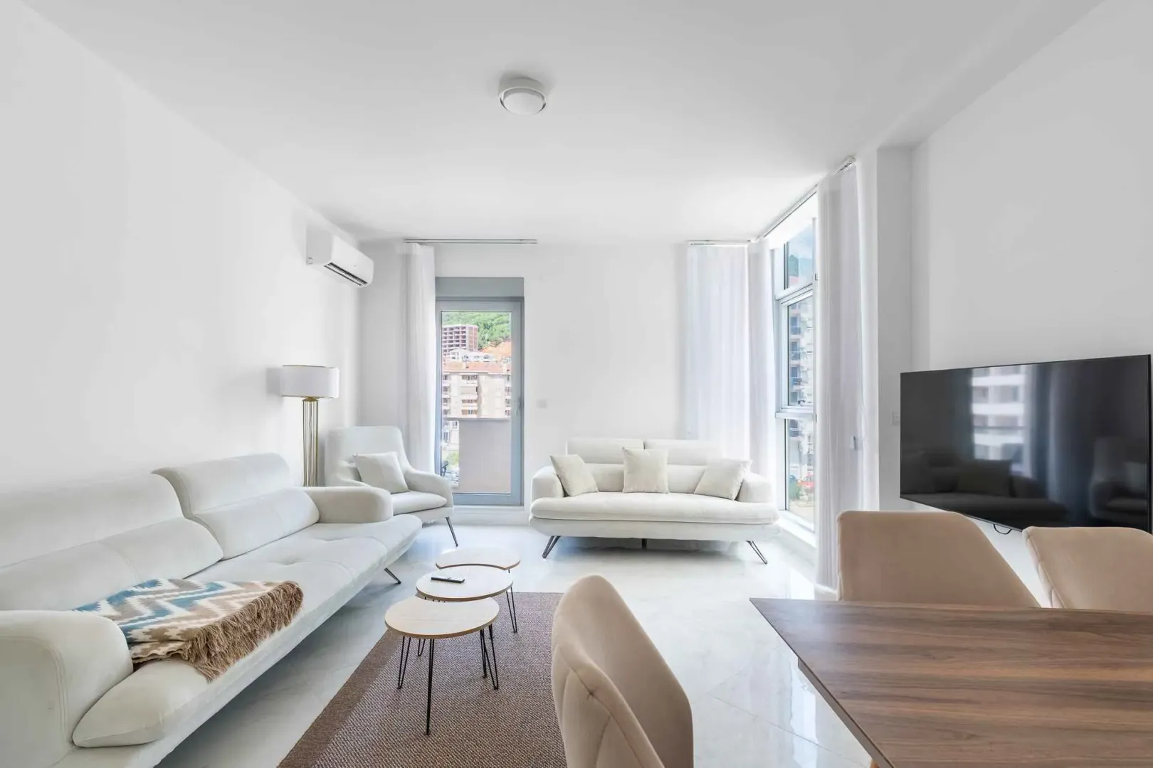Bright and spacious living room with sofa set and dining area.