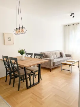 Living room with dining area, sofa and wooden flooring. - image 2