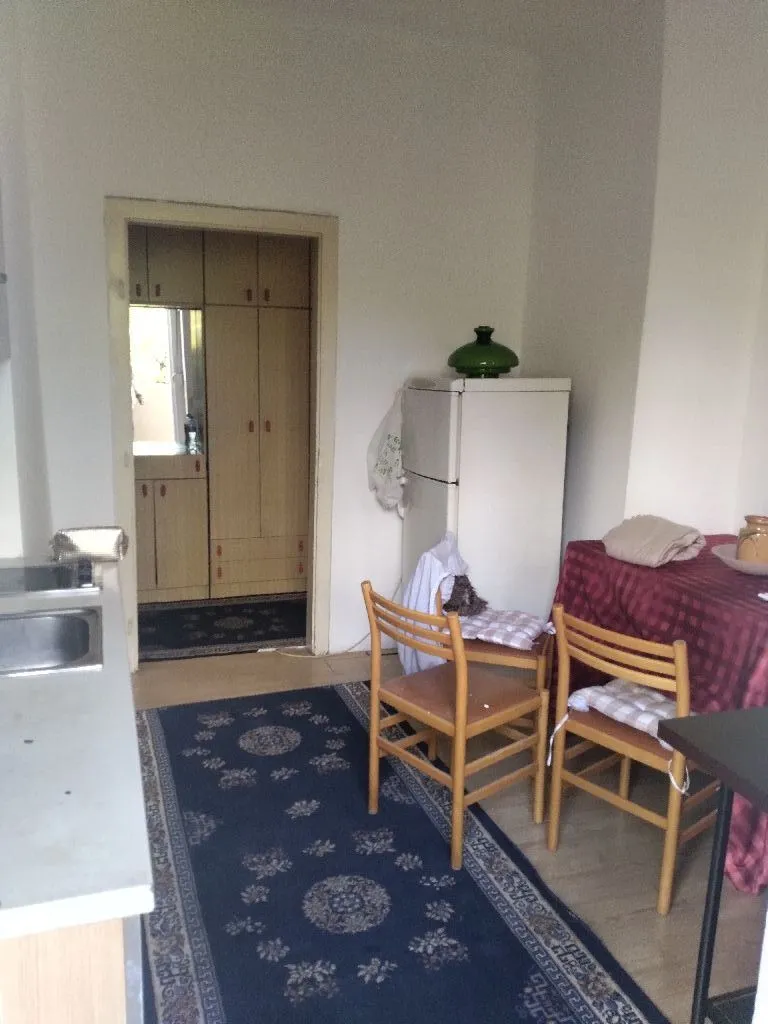 Kitchen with a dining table and chairs, overlooking the hallway.