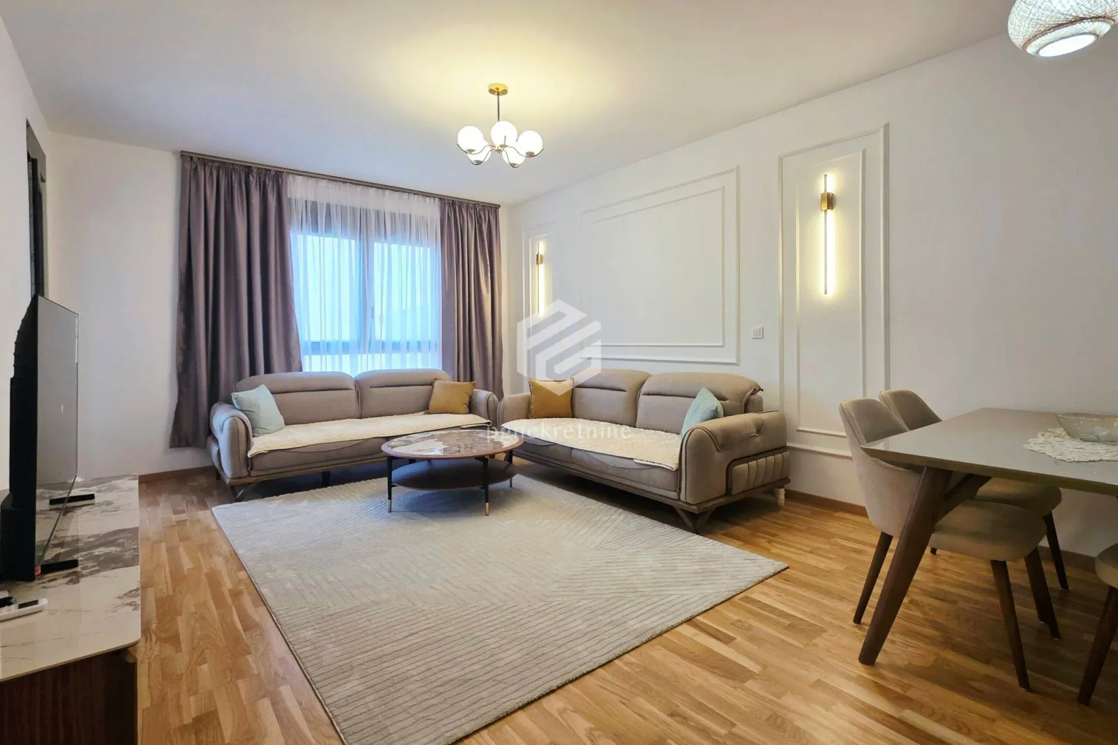 Spacious living room with sofa set, coffee table, and dining table.