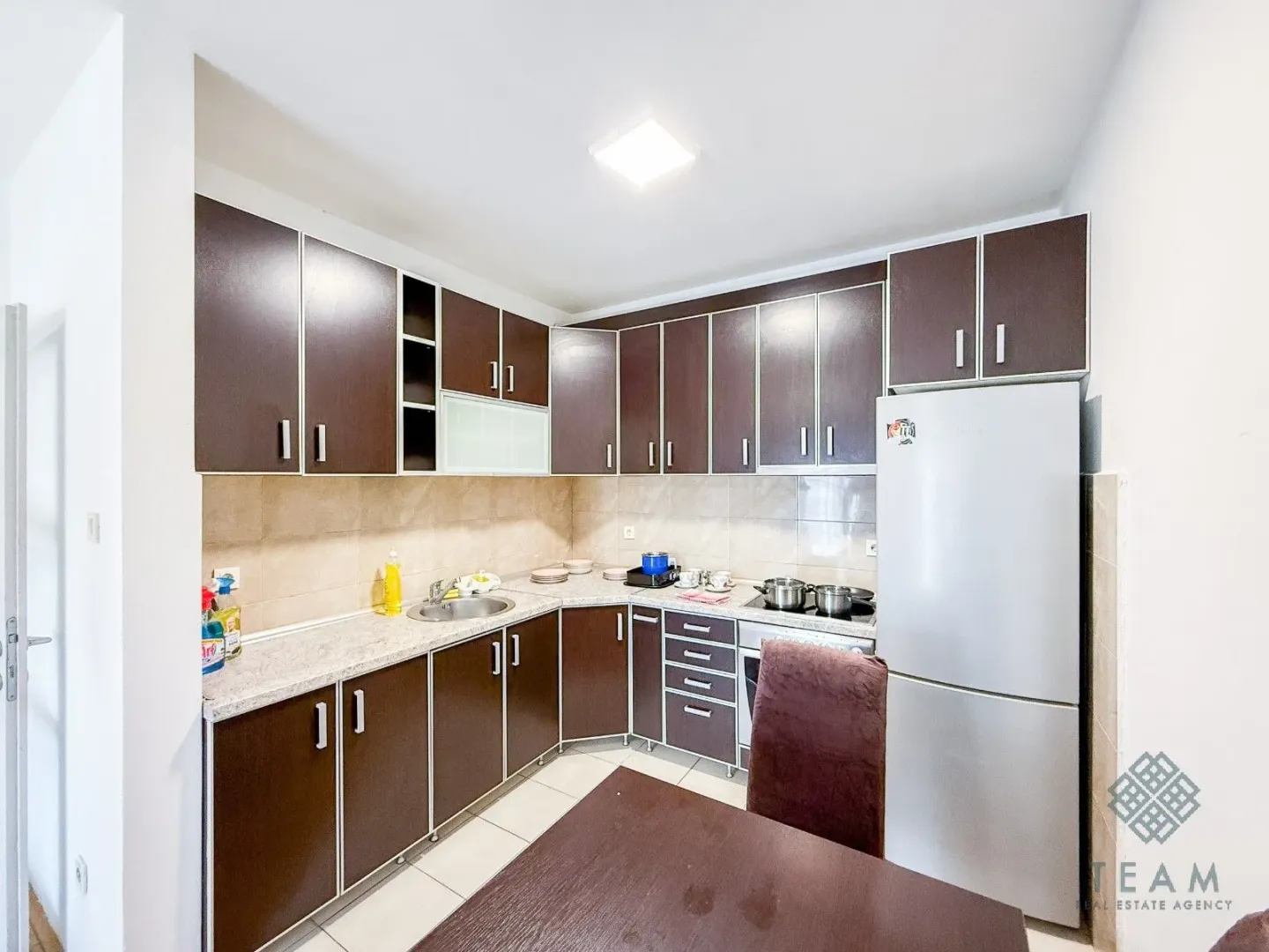 Kitchen with dark wooden cabinetry and a white refrigerator.