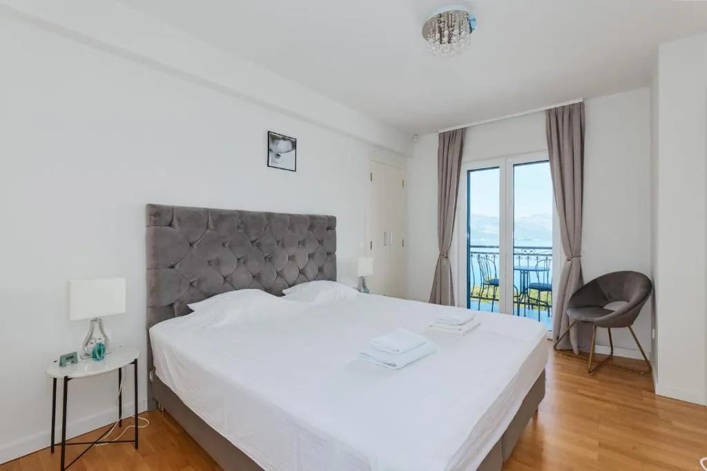 Spacious bedroom with a double bed and access to a terrace with a sea view.