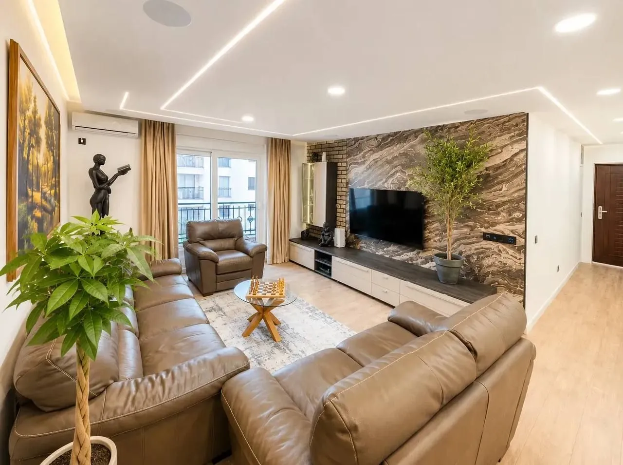 Modern and bright living room with a sofa set and TV unit.